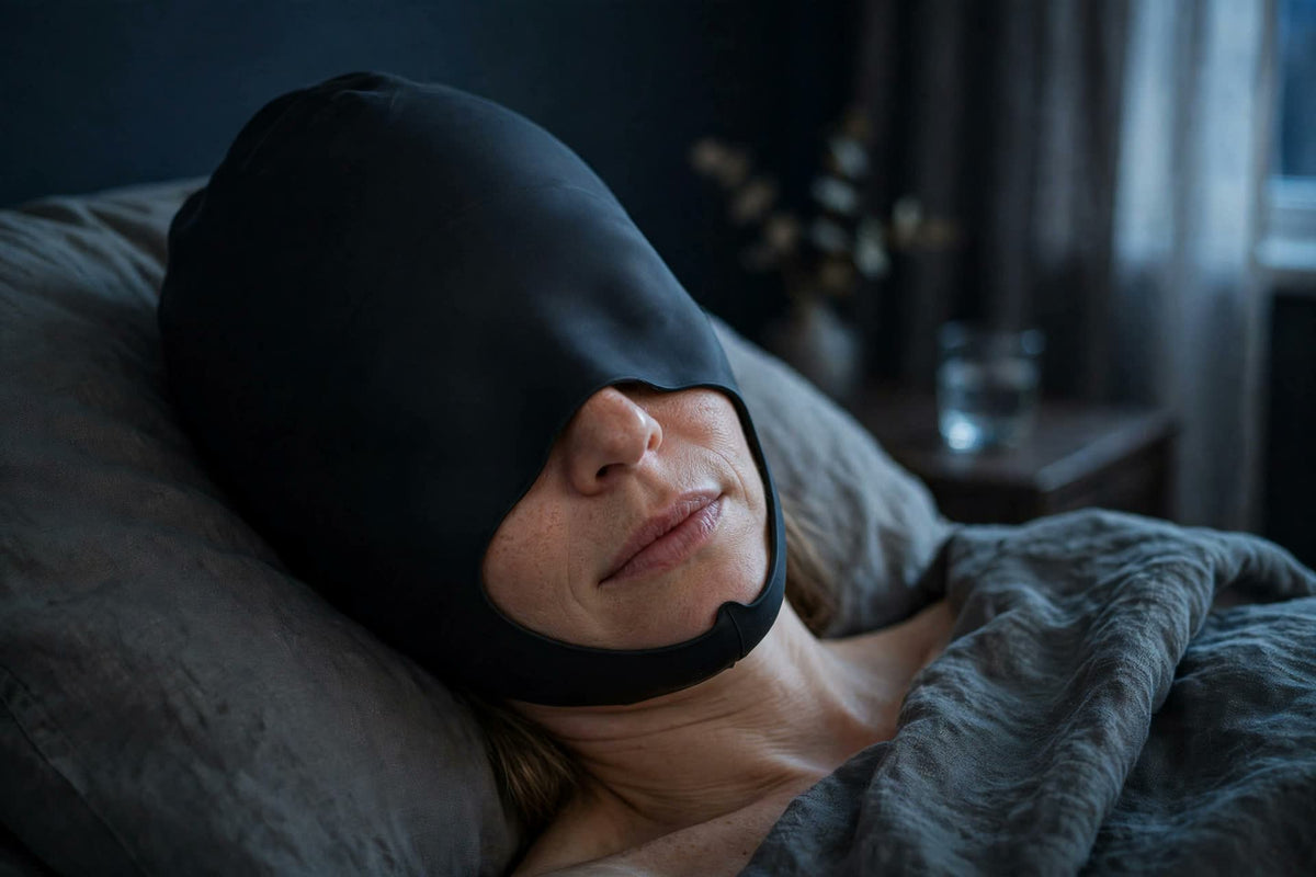 Woman resting in a dark room wearing the ReliefCap Pro gel cap
